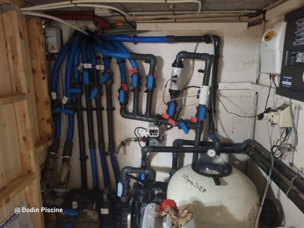 Local technique de piscine avant rénovation, montrant tuyauteries, filtre et traitement automatique existants, diagnostic Dodin Piscine.