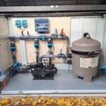 Local technique de piscine complet avec pompe, filtre à cartouche et système de régulation automatique installé par Dodin Piscine